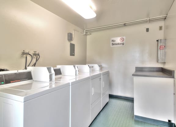 A laundry room with a washer and dryer and a no smoking sign.