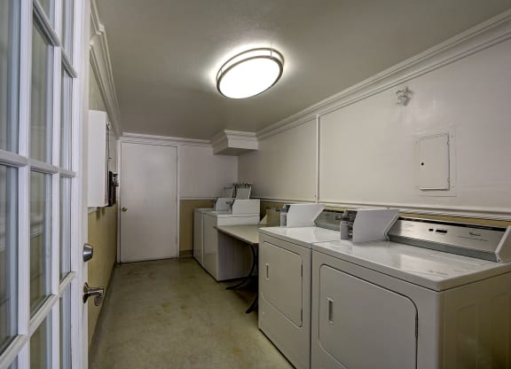 A white washing machine and dryer in a laundry room.