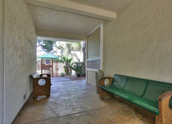 A green bench sits in a patio area.