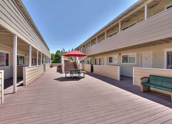 a long deck with benches and a umbrella