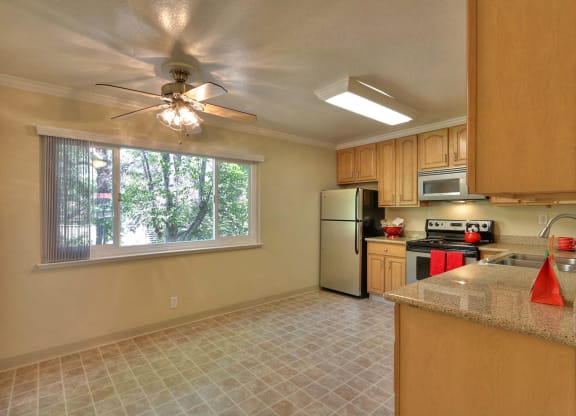 a kitchen with a ceiling fan and a window