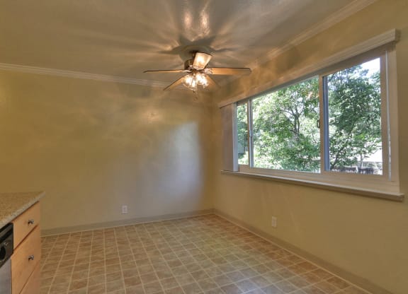 a kitchen with a large window and a ceiling fan