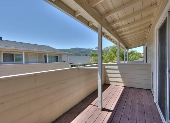 a view off the deck with trees and mountains in the background