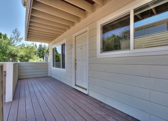 the front deck of a house with a white door