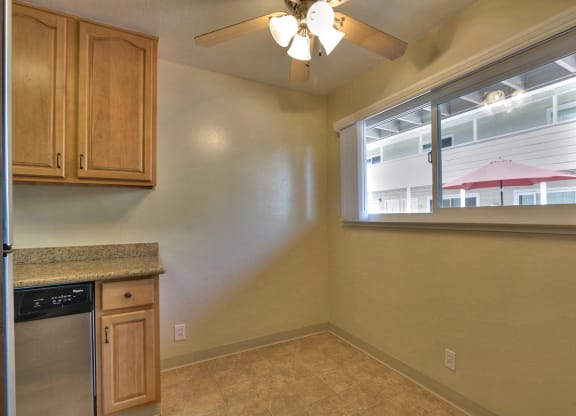 a kitchen with a window and a dishwasher and a ceiling fan
