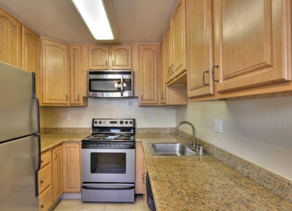 a kitchen with wooden cabinets and stainless steel appliances