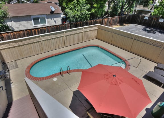 a swimming pool with an umbrella in a backyard