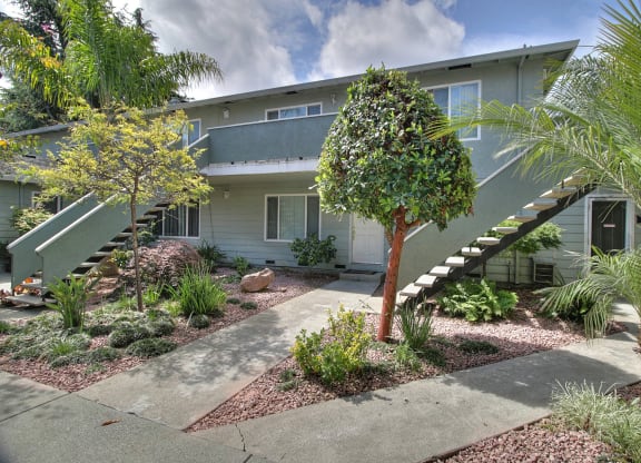 a house with stairs and a garden in front of it