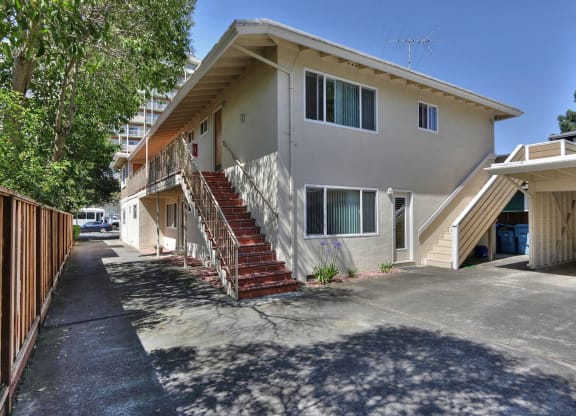 an apartment building with stairs and a driveway