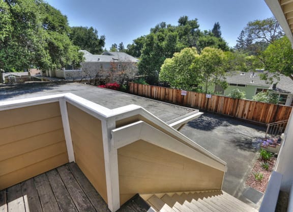 a deck with a roof and a backyard with trees