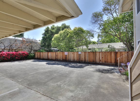 the driveway of a house with a wooden fence
