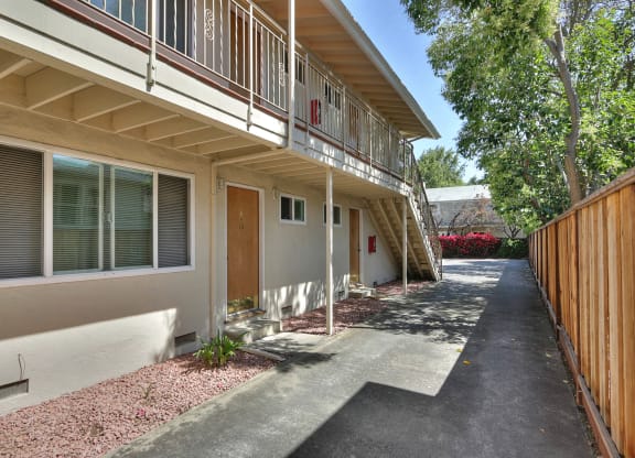 the front entrance of a building with a porch and a driveway
