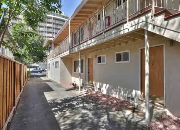 an apartment building with a sidewalk and a fire hydrant