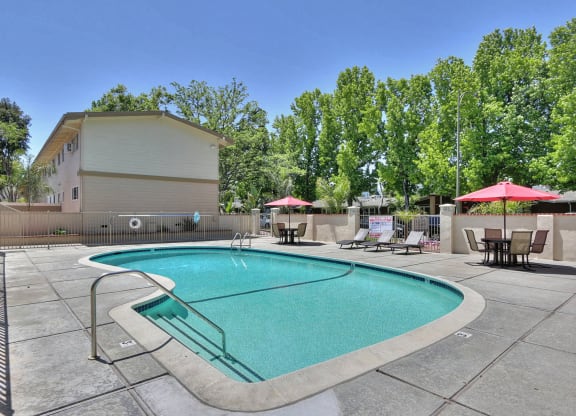 A small pool with a slide in the middle of a patio.