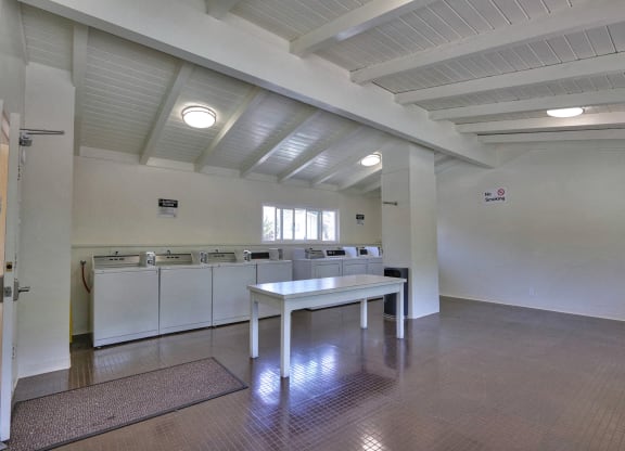 A large, empty room with a table and chairs in the center.