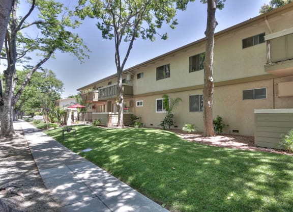 A sunny day at a residential area with apartment buildings and green lawns.