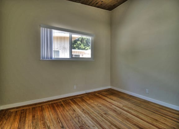 A room with wooden flooring and a window.