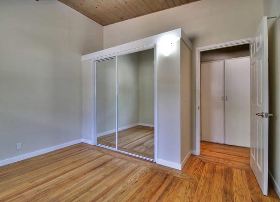A room with a sliding door and wooden floors.