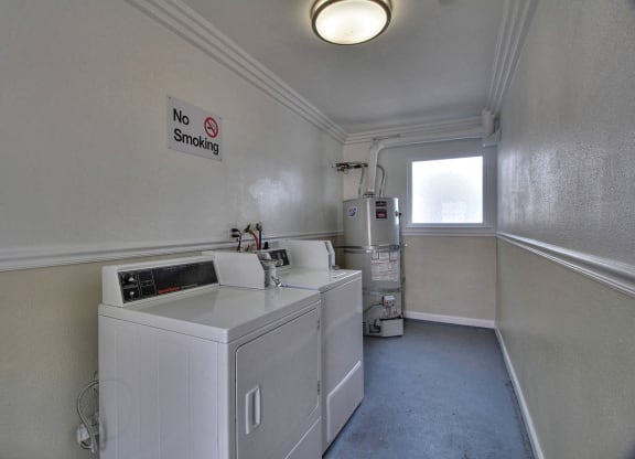 a laundry room with two machines and a window