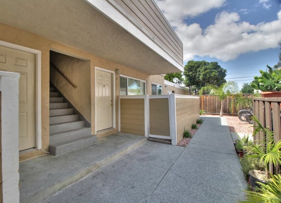 the front of a building with stairs and a sidewalk