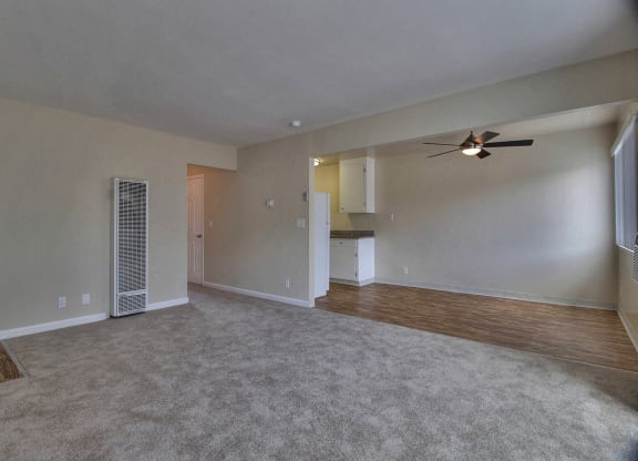 an empty living room with a ceiling fan