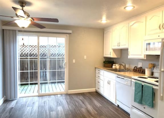 a kitchen with white cabinets and a sliding glass door