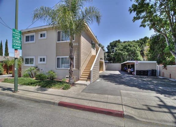 a building with stairs and a driveway in front of it