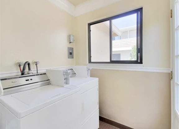 a laundry room with a washing machine and a window