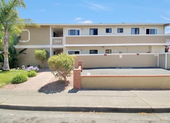 the front of an apartment building with a sidewalk in front of it