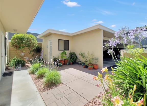 a patio in front of a house with potted plants