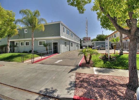 A building with a green roof and a red and white striped curb in front of it.