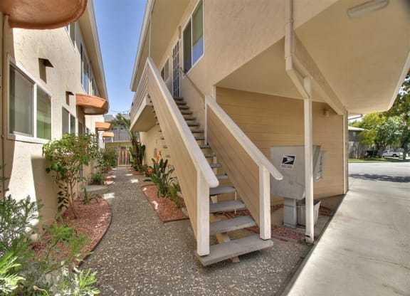 A concrete pathway leads to a mailbox on a residential building.
