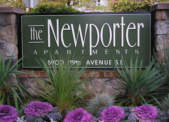 The Newporter Apartments sign is in front of a stone wall.
