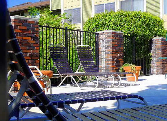 A pool area with chairs and a table.