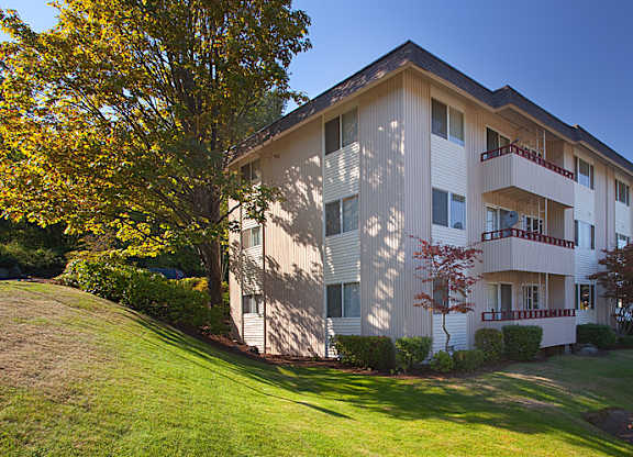 A large apartment building with a tree in front of it.