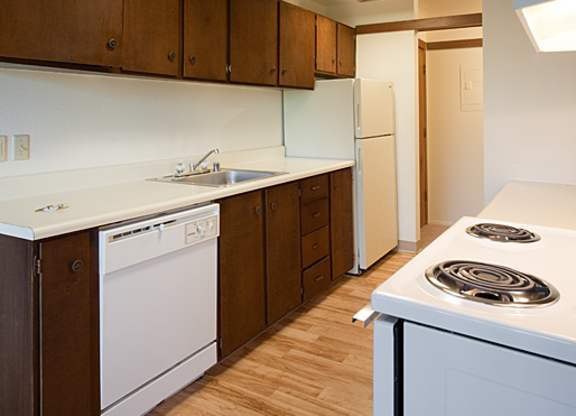A kitchen with white appliances and wooden cabinets.
