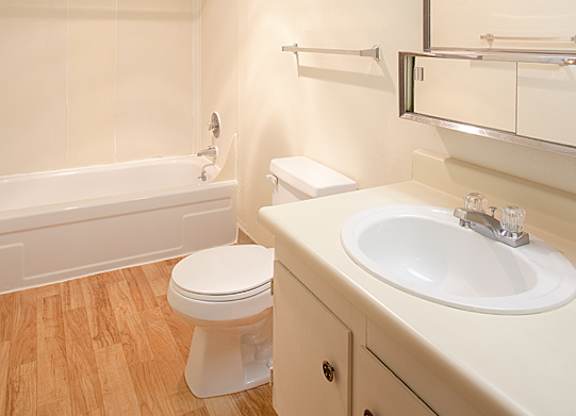A white toilet sits next to a sink in a bathroom.