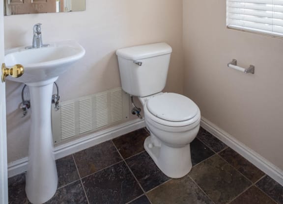 A white toilet sits next to a sink in a bathroom.