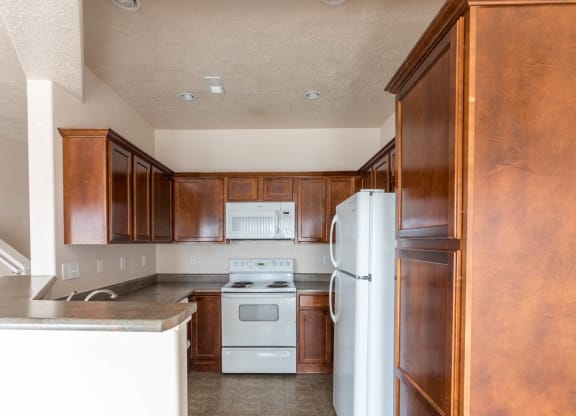 A kitchen with a white stove and refrigerator.
