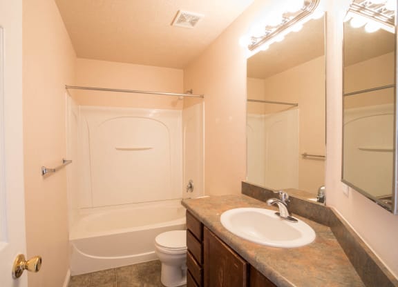 A bathroom with a toilet, sink, and bathtub.