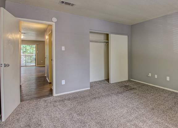 A room with carpeted floor and two doors.
