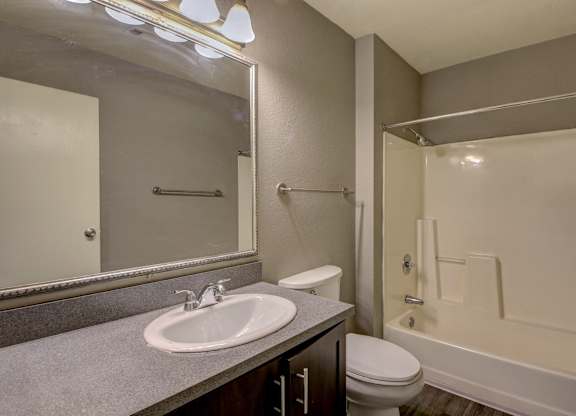 A bathroom with a sink, toilet, and bathtub.