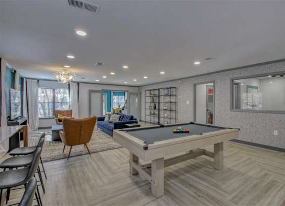 A room with a pool table and a chair.