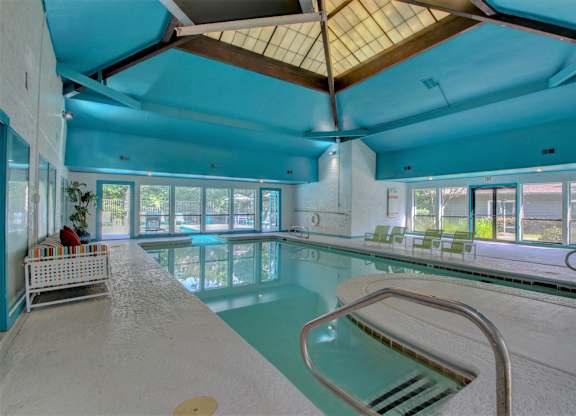 A large indoor swimming pool with a wooden ceiling.