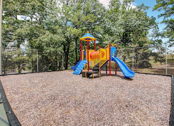A playground with a blue and yellow slide.