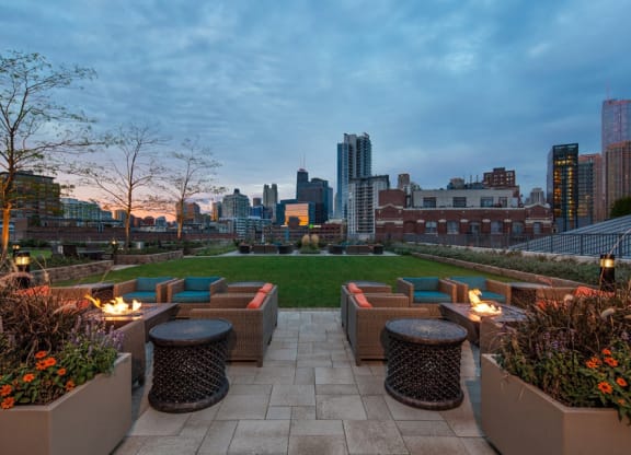 Outdoor fire pits with views of the Chicago skyline and green terrace area at Kingsbury Plaza, Chicago