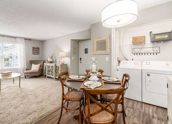 A dining room with a wooden table set for two.