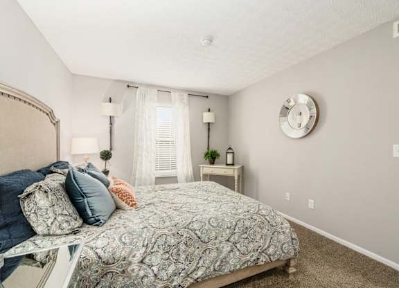 A bedroom with a large bed and a clock on the wall.