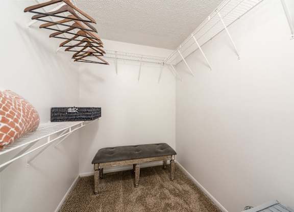 A small room with a bench and a coat hanger.