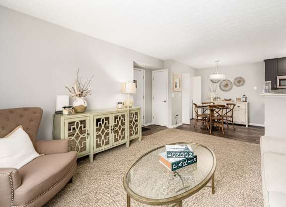A living room with a sofa, a coffee table, and a dining area in the background.